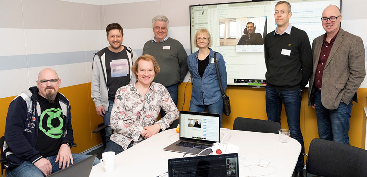 Den tekniska kommittén för version två av SS 12 000 samlad, i verkliga livet och via nätverk. 